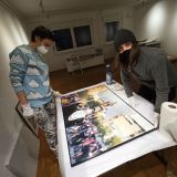 Dominika und Valerie rahmen Fotografien für die Ausstellung „Chile ist erwacht! Repression und sozialer Widerstand - gestern und heute.“